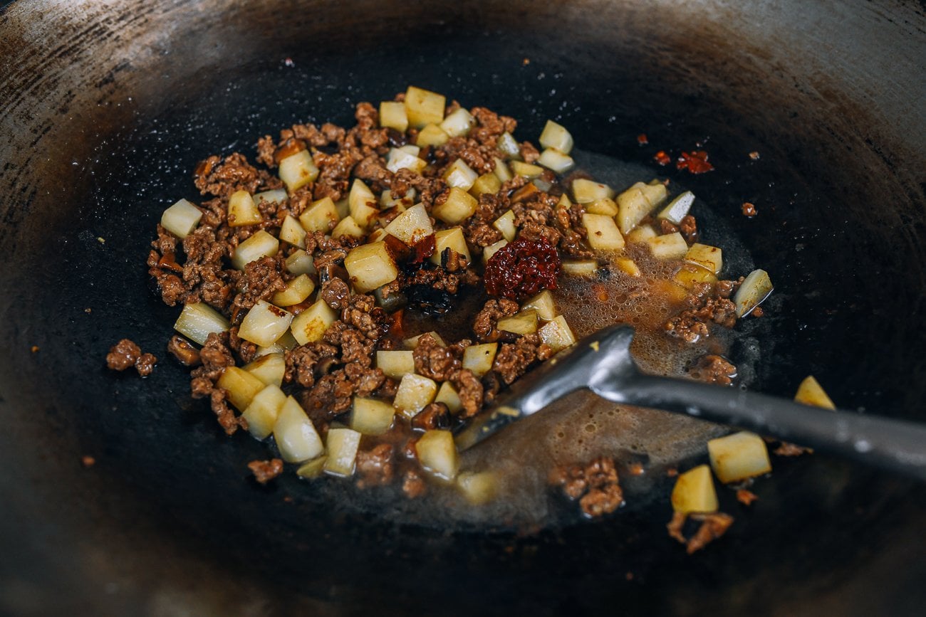 spicy douban jiang in pork and potato dish in wok