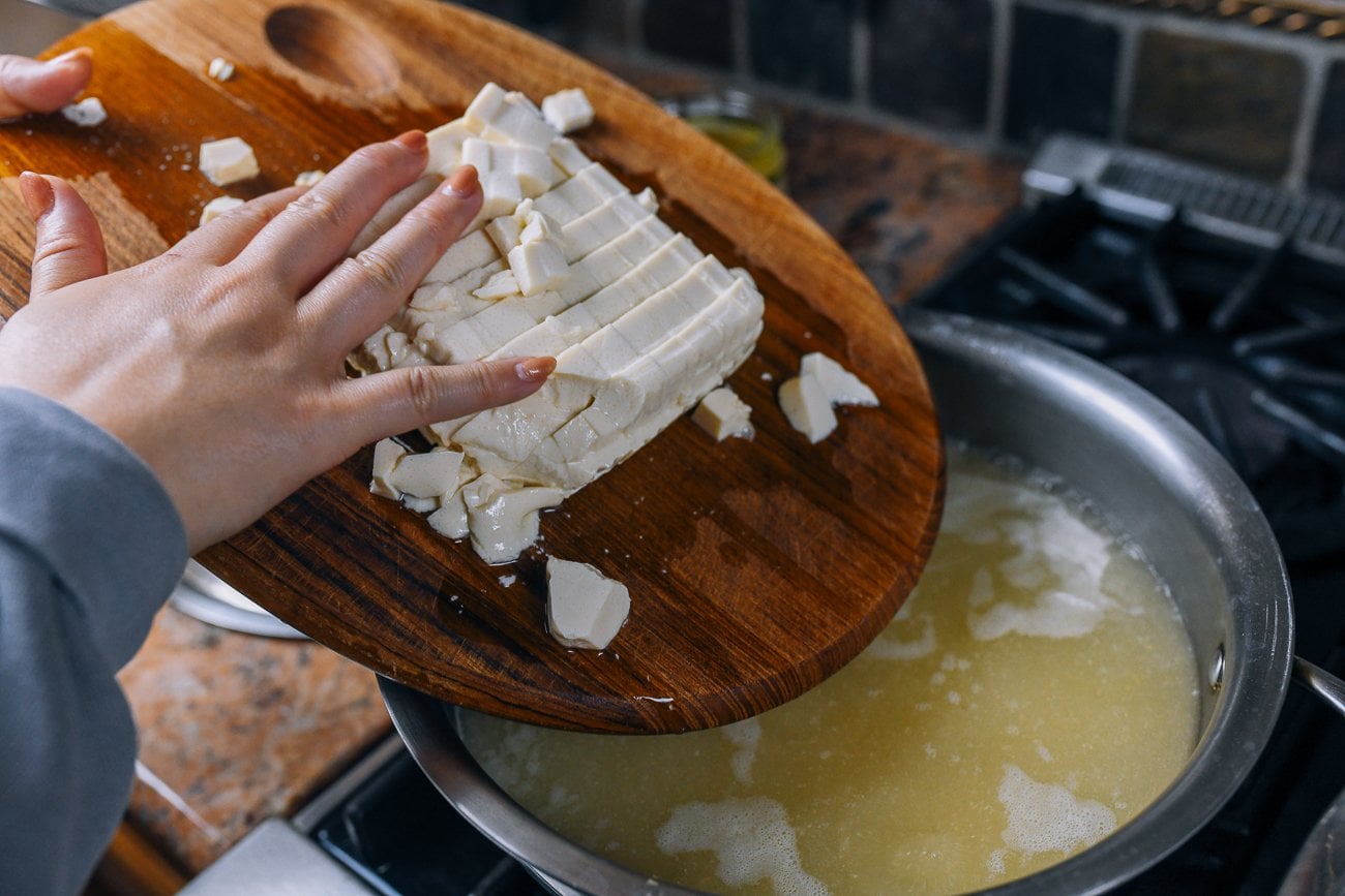 adding cubed silken tofu to soup pot