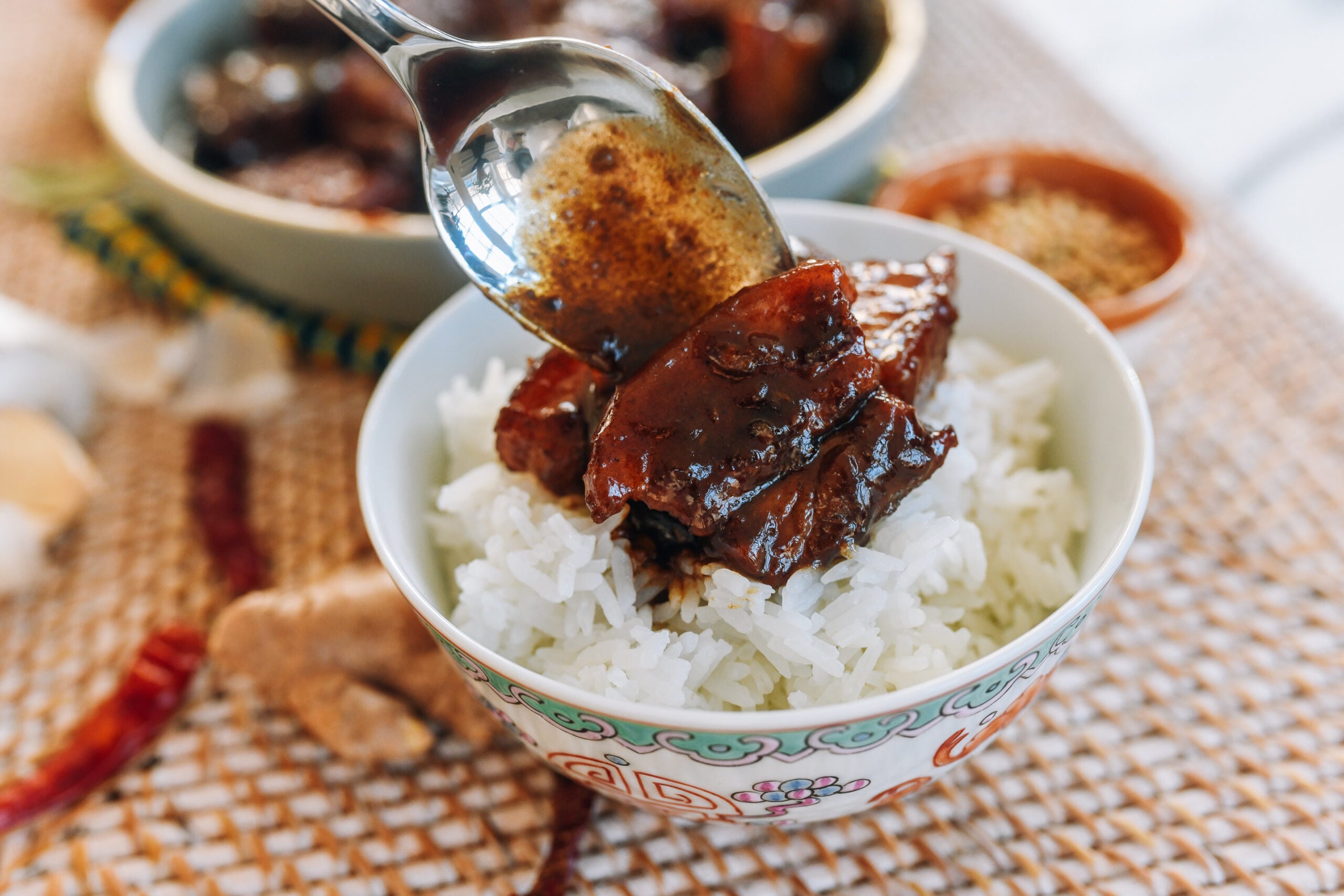 Scooping indonesian chinese pork belly over rice