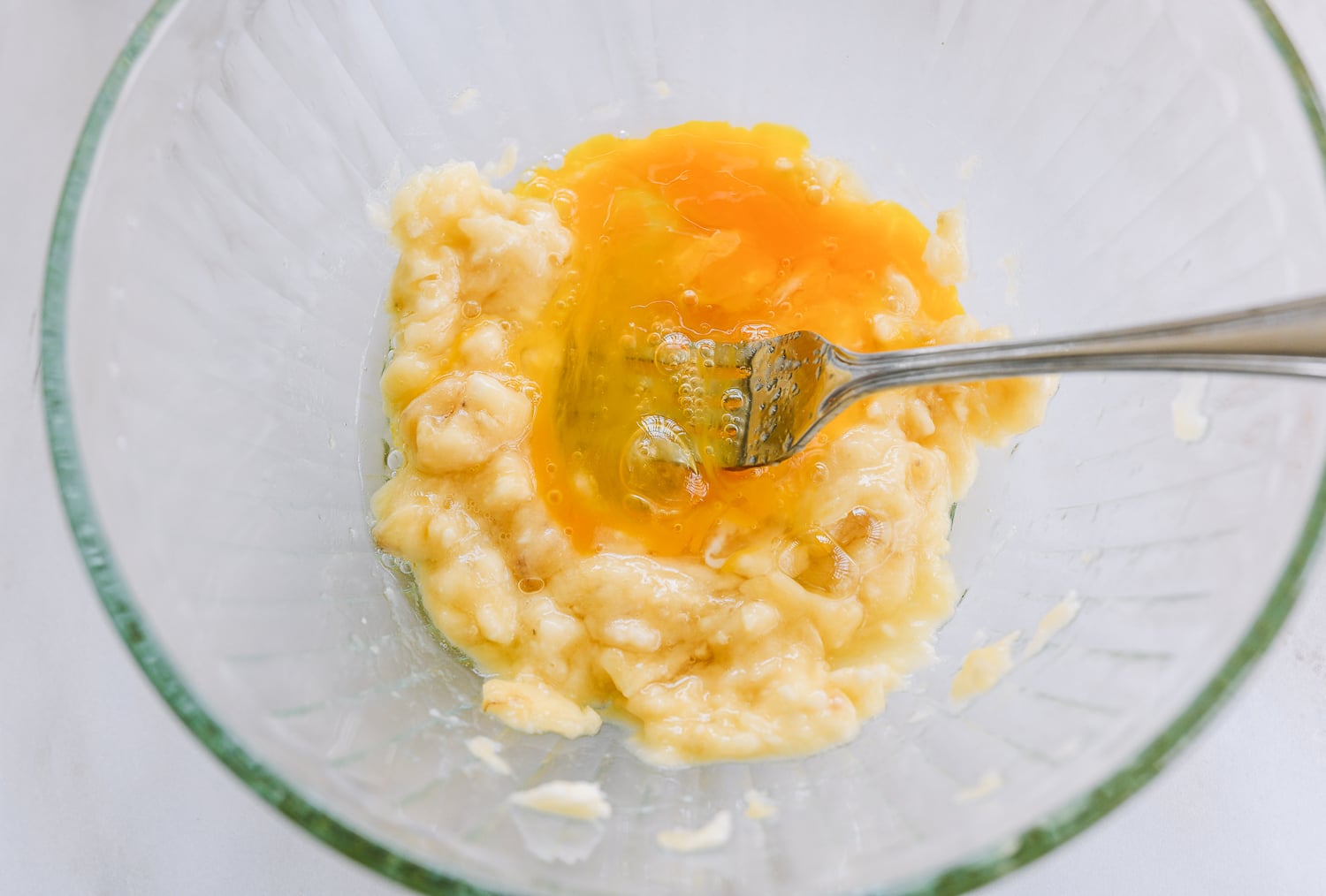 beating egg into mashed banana