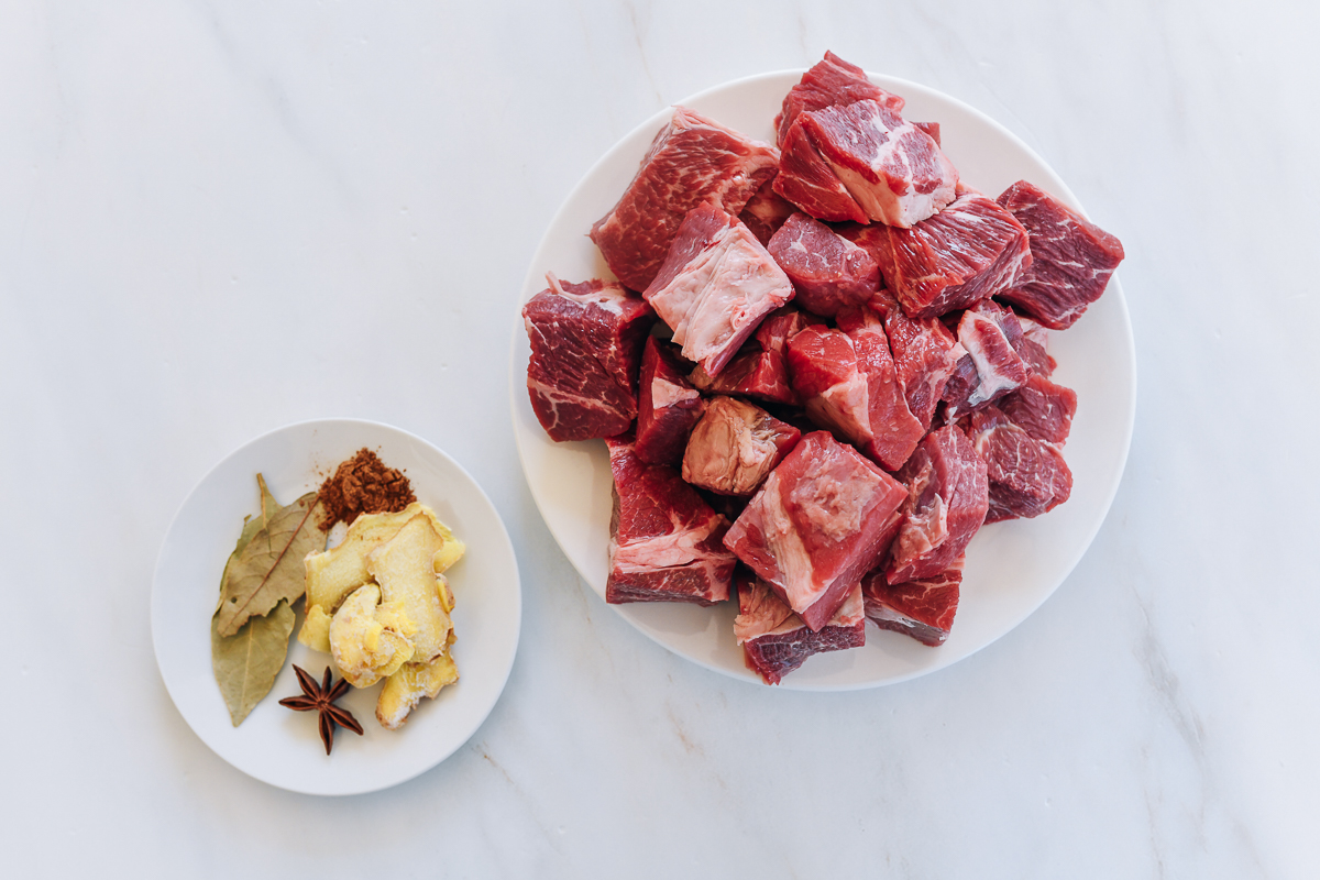 beef stew meat on plate, with aromatics