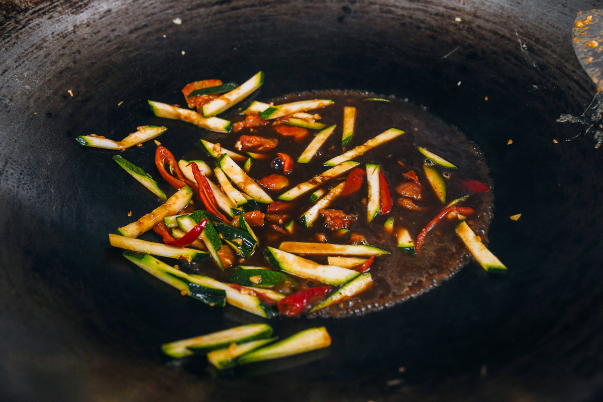 prepared sauce mixture added to vegetables in wok