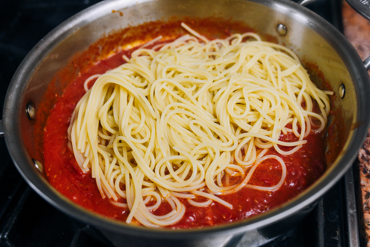 spaghetti added to tomato sauce