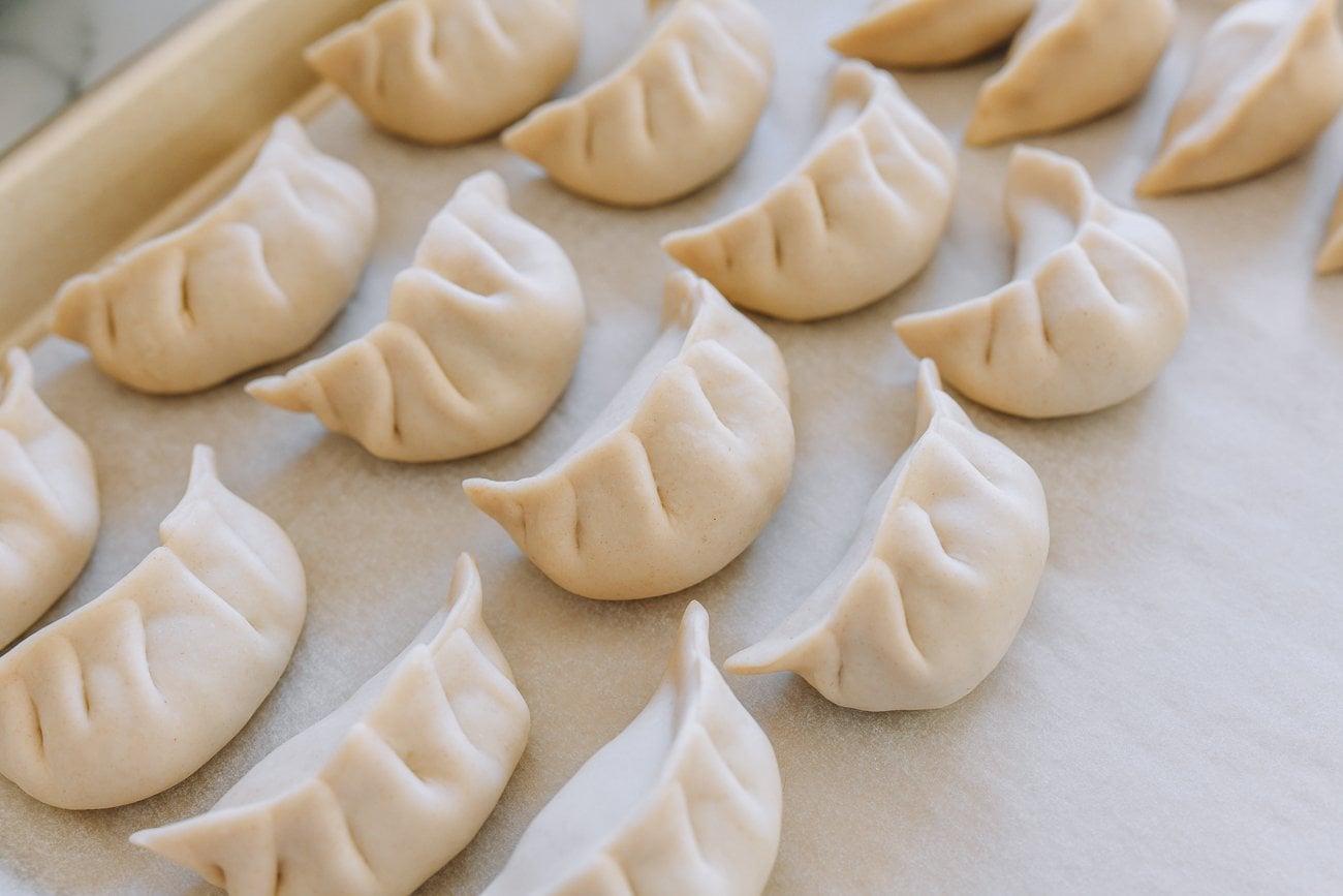 assembled dumplings on parchment lined sheet pan