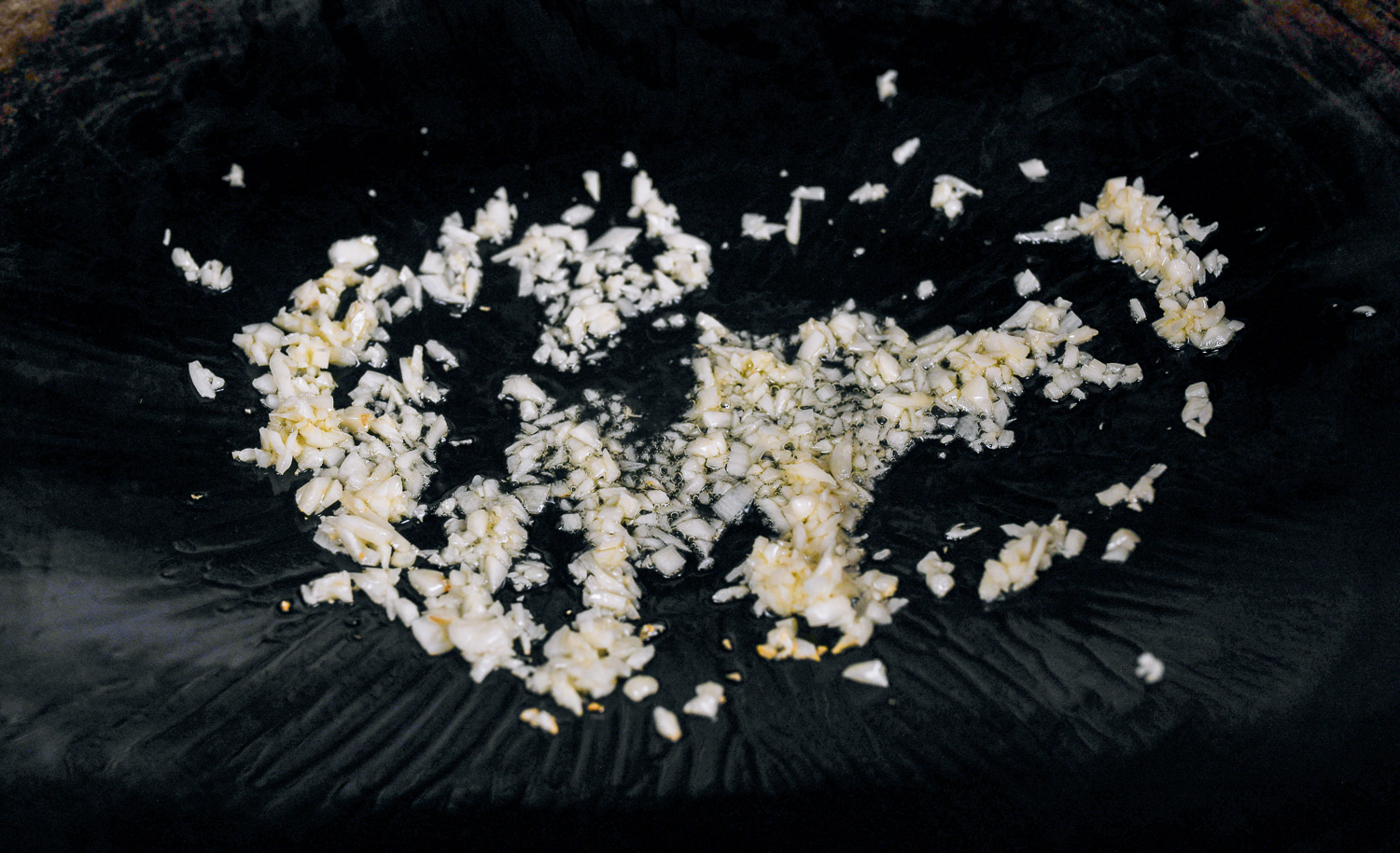 minced garlic in oiled wok