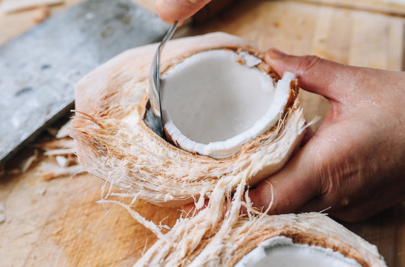 scooping flesh from young coconut