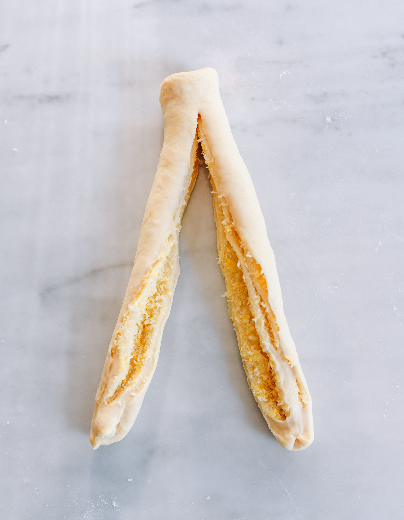 Cutting dough cigar in half lengthwise