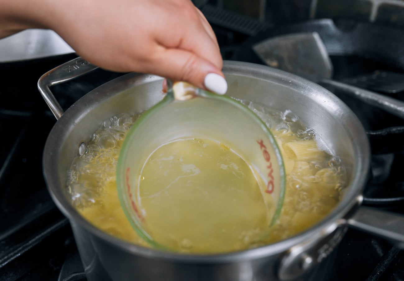 reserving pasta cooking water in measuring cup