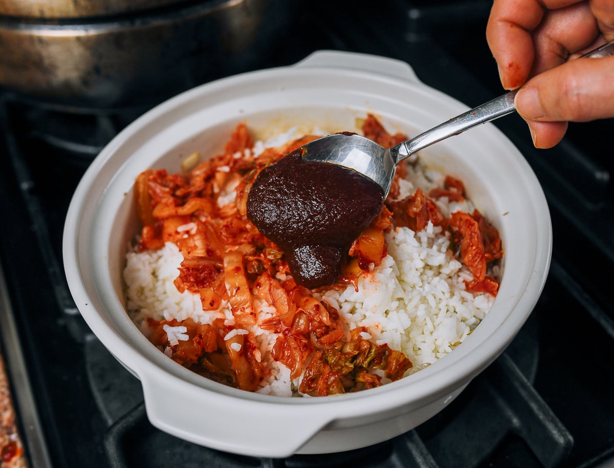 adding gochujang to rice and kimchi