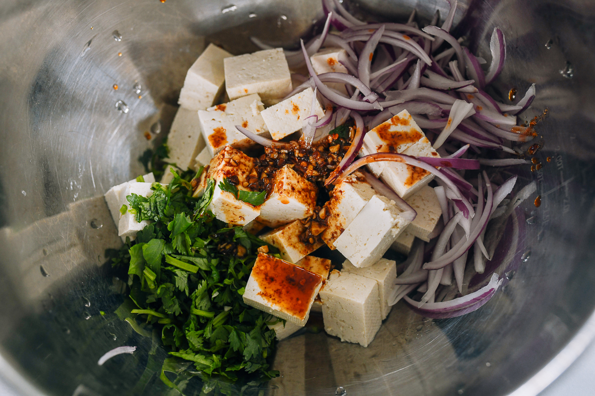 tofu, red onion, cilantro, and dressing in metal bowl