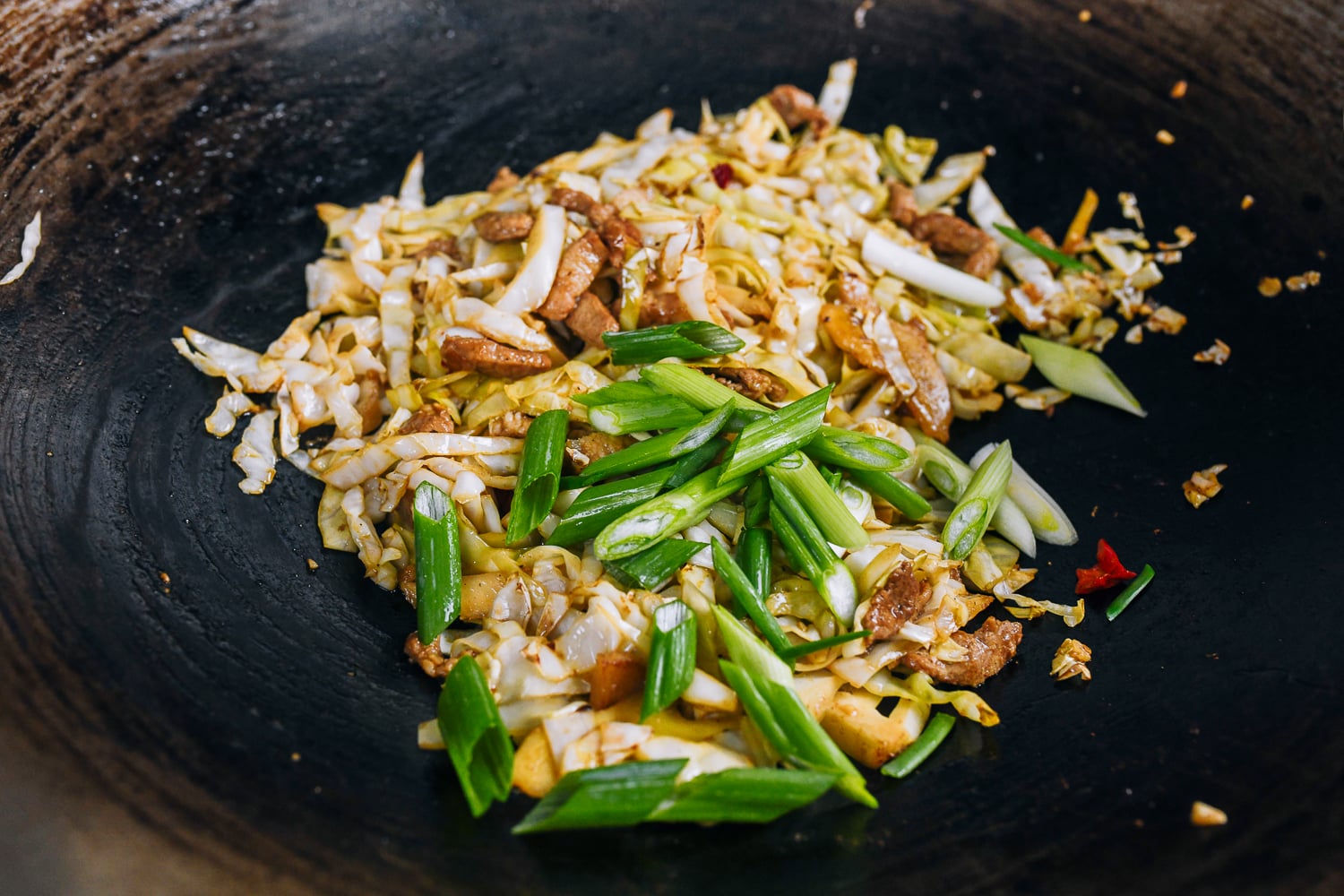 adding scallions to stir-fry