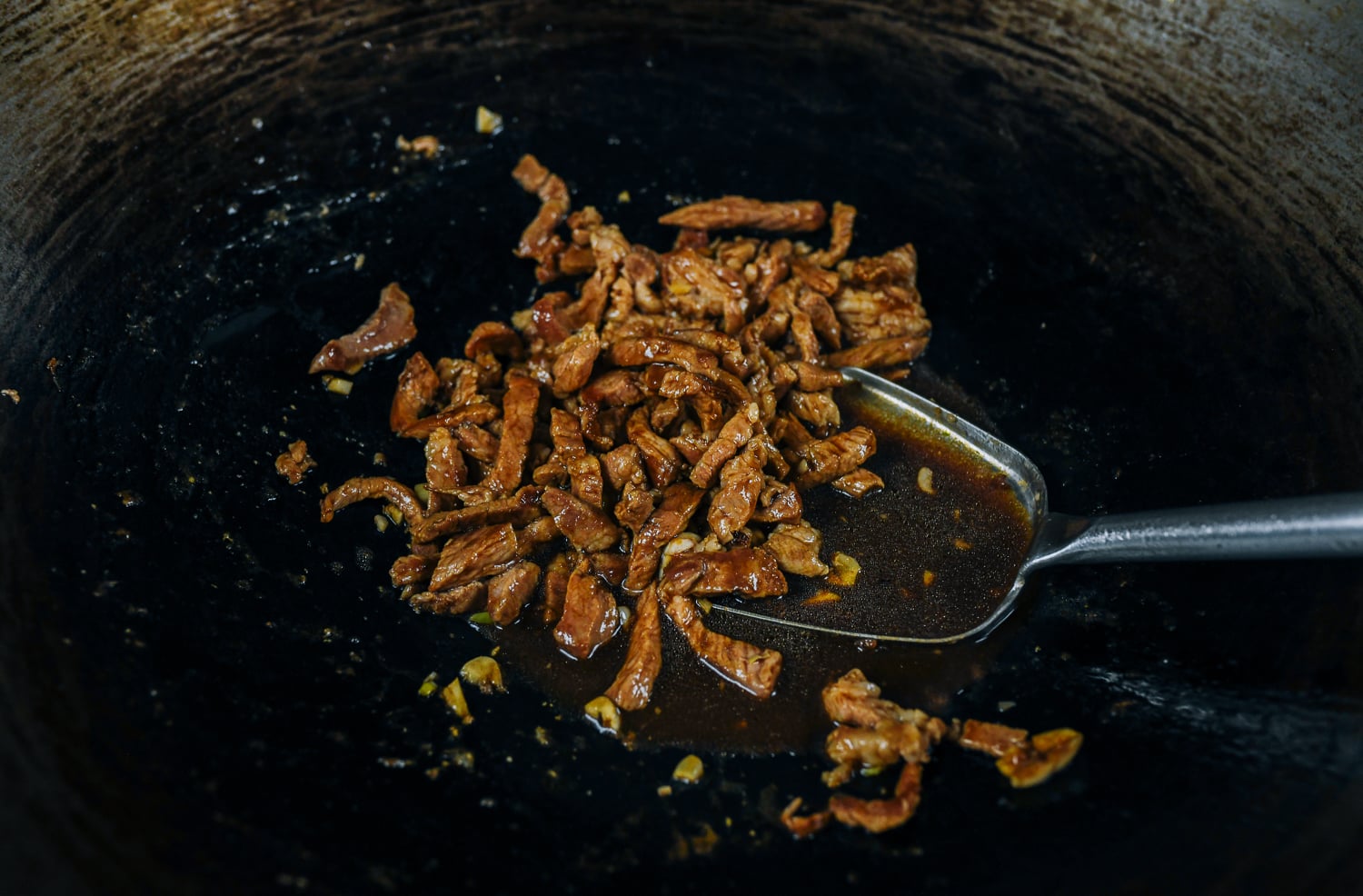 stir-fried pork strips with sauce in wok