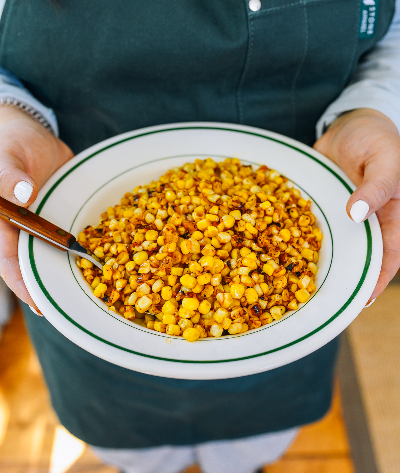 Kaitlin holding dish of fried corn