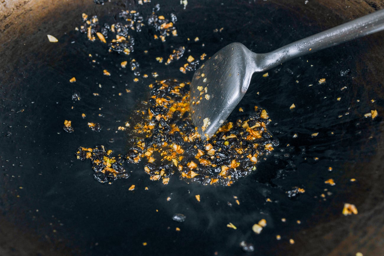 Shaoxing wine added to black bean and garlic in wok