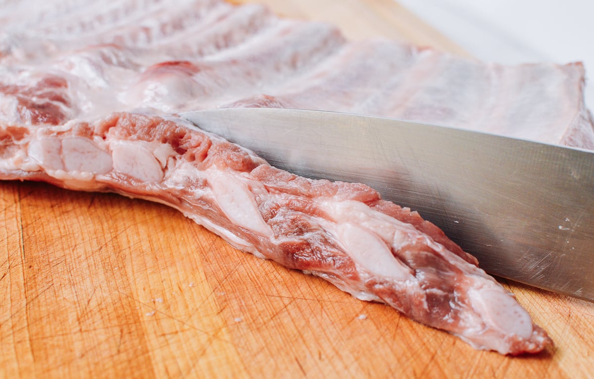 knife trimming rib tips on pork ribs