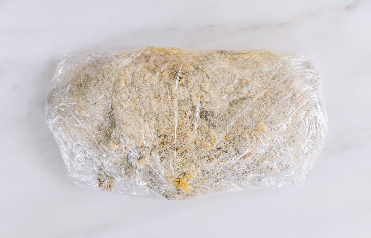 breaded wor shu duck wrapped in plastic wrap before cooking